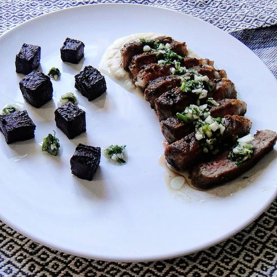 Pan seared New York strip on the bed of turnip pure, topped with chimichurri sauce, and garnished with beetroot cubes...